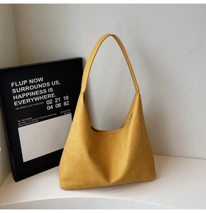 Detail view of mustard yellow leather hobo bag with minimalist seamless shoulder strap