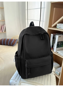 Detail eines schwarzen minimalistischen Rucksacks auf einem Koffer im Schlafzimmer-Ambiente