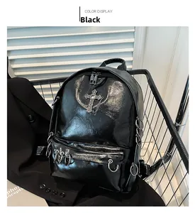 Detail of black punk backpack featuring metal cross chains and polished rivet accents