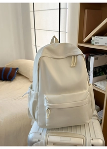 Details des beigen Rucksacks auf einem Koffer mit Fronttasche und gepolsterten Gurten