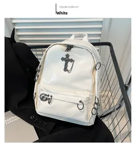 White Gothic PU backpack detail featuring large metal cross pendant and chains on black suit