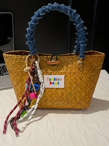 Handmade woven straw beach bag with denim handles and colorful bohemian bead charms