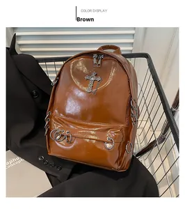 Close-up of brown PU leather backpack with vintage metal cross and decorative silver rings