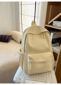 Detailansicht des gelben Nylon-Rucksacks mit großem Fassungsvermögen auf einem Koffer