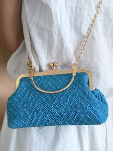 Blue woven clamshell bag with gold metal frame and ball clasp lock on metal chain strap