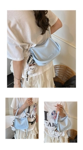 Detail view of light blue semi-circle crossbody bag with silver chain and plush puppy charm