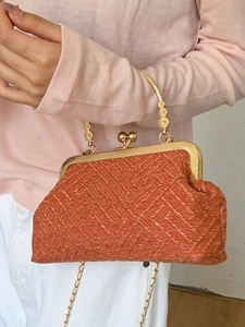 Elegant woven shell bag in rust red with golden metal clasp and chain strap for evening