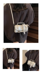 Detail of silver cylindrical crossbody bag featuring pearls and lace bow accents