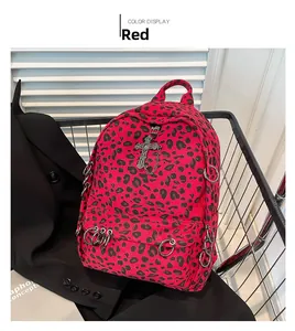 Detail view of red leopard print canvas backpack with metallic silver punk cross charms