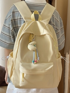 Minimalistischer hellgelber Schulrucksack mit verstellbaren Trägern und Mond-Plüschanhänger