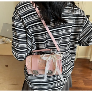 Pink faux leather crossbody bag detail featuring pearl lace bow and silver rhinestone trim