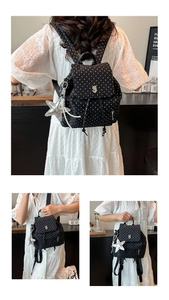 Detail of black star print backpack with metallic logo and star pendant accessory
