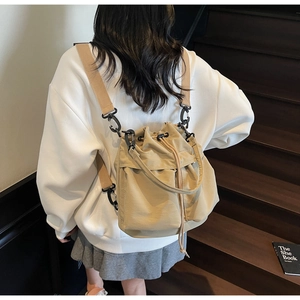 Borsa a secchiello kaki con coulisse su modella che mostra spalline e trama di tela