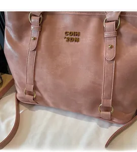 Details der rosa Einkaufstasche aus genarbtem Leder mit goldener Schnalle und Logo