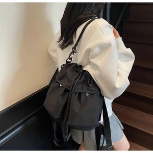Vista laterale di un secchiello in nylon nero minimalista indossato da una modella
