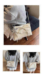 Detail of ballet style shoulder bag featuring cream pleated fabric and silver starfish charm