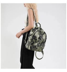 Side view of punk style camouflage backpack with silver metal rings and cross pendant detail