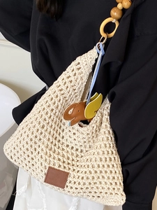 Handwoven cream crochet tote bag with wooden bead straps and elephant charm