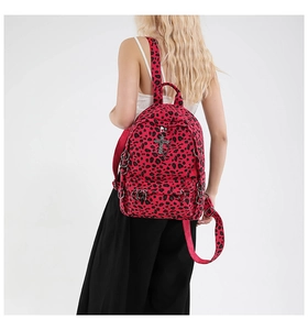 Detail of red leopard print backpack with silver cross charms and metal rings