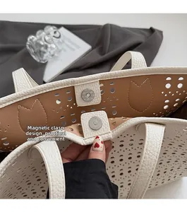 Détail du sac blanc avec motif découpé au laser et fermeture par bouton magnétique sûr