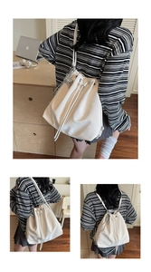 Detailed views of white drawstring bucket backpack with silver heart and star charms