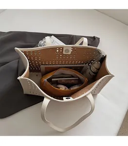 Détail du sac cabas beige ajouré montrant sa grande capacité et sa pochette intérieure