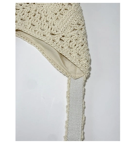 Detail view of woven crochet bag interior with smooth lining and decorative straps