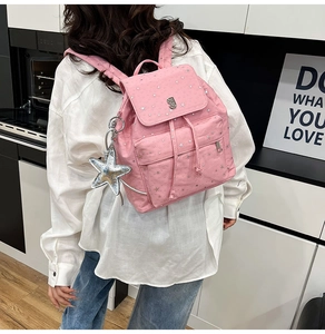 Pink backpack with silver stars, star pendant, and drawstrings shown on a model