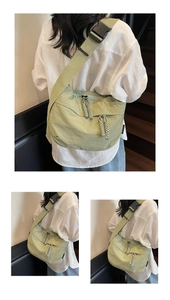 Detail of avocado green nylon dumpling bag showing multi-zip texture and woven cord pullers