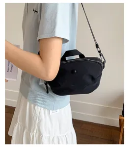 Détail d'un sac à bandoulière en nylon noir en forme de croissant avec sangle tissée