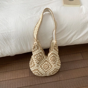 Detailed macro view of retro floral knit pattern on this beige hand-woven shoulder bag