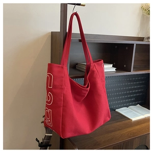 Detail of red canvas tote bag with retro 199 print hanging in a vintage studio setup