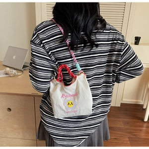 Dettaglio della borsa a secchiello in tela giapponese con ricamo Kawaii e tracolla intrecciata
