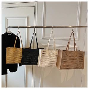 Gros plan de quatre sacs cabas ajourés en cuir jaune, noir, blanc et marron