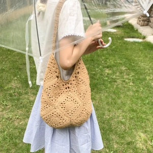 Detail of hand-woven crochet tote bag featuring intricate floral hollow patterns for summer
