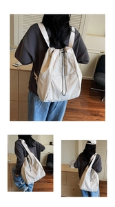 Detail of off-white drawstring backpack with wide straps and textured nylon fabric