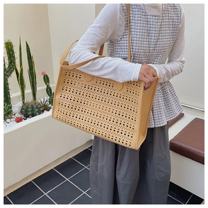 Vue détaillée du sac cabas en cuir jaune moutarde avec motifs ajourés découpés au laser