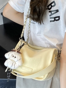 Sac à bandoulière crème avec chaîne argentée et pendentif chiot peluche sur mannequin