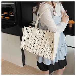 Vue détaillée du sac cabas blanc perforé avec découpes circulaires et longue bandoulière