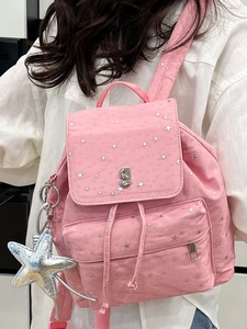 Pink canvas backpack with silver star patterns and a large metallic star charm accessory