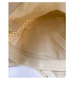 Close-up detail of the woven beach bag featuring a zipper closure and inner pocket lining