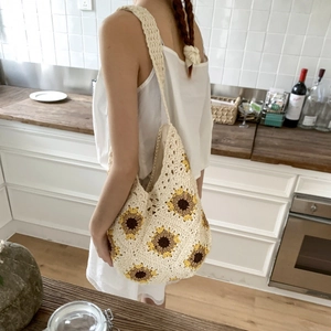 Detailed view of handmade woven tote bag with vibrant sunflower crochet patterns