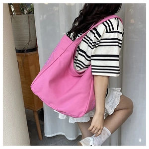 Detail of pink canvas tote bag with blue lettering print showing texture and size