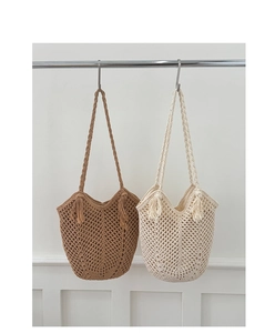 Detail of woven mesh texture and fringe tassels on beach tote bags in brown and beige