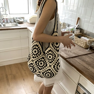 Macro view of woven bohemian tote bag featuring handmade geometric floral patterns