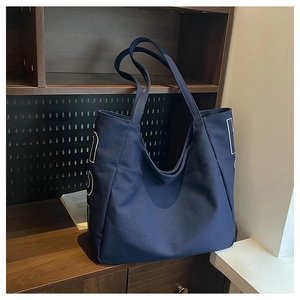 Detail of dark blue canvas tote bag with white art print on a vintage wooden shelf