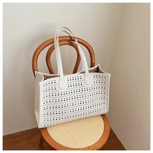 Détail du motif ajouré découpé au laser sur le sac cabas en cuir blanc texturé