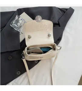 Vue intérieure montrant la grande capacité du sac bandoulière en cuir PU crème