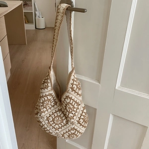 Detail view of Bohemian crochet tote bag with geometric floral patterns on a white door