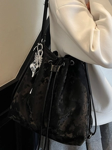 Vintage black velvet drawstring bucket bag with silver wing charm for elegant daily commute